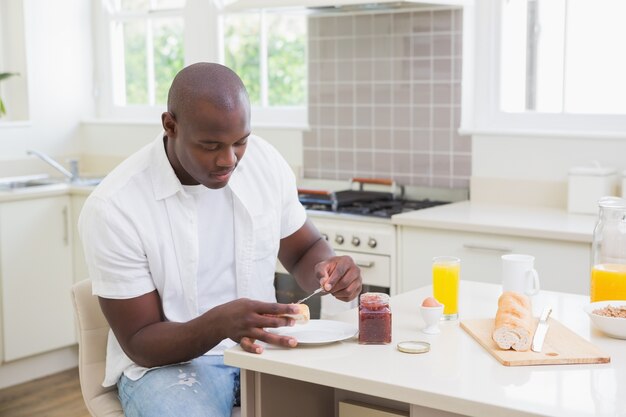 Homem sorridente tomando seu café da manhã