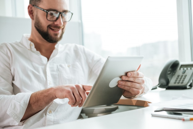 Homem sorridente, usando computador tablet