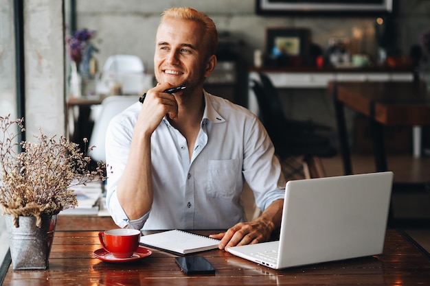 Homem sorridente usando laptop em casa