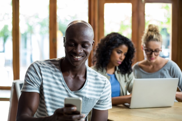 Homem sorridente, usando telefone móvel