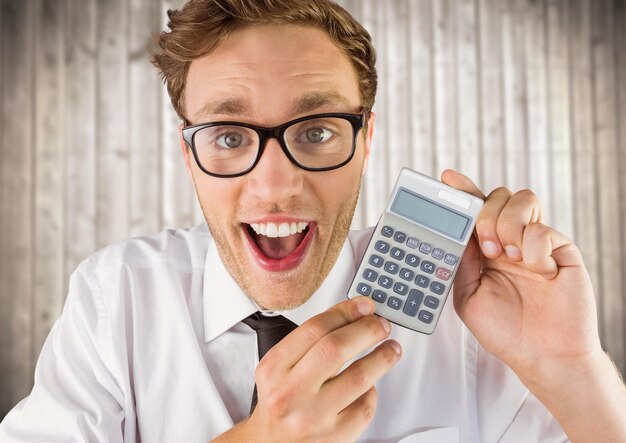 Homem sorrindo com calculadora contra painel de madeira embaçada
