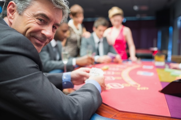 Homem sorrindo na mesa de poker