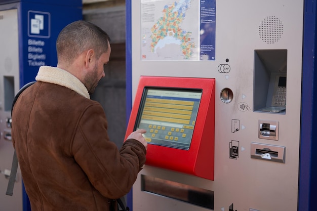 Homem sozinho comprando uma passagem de trem