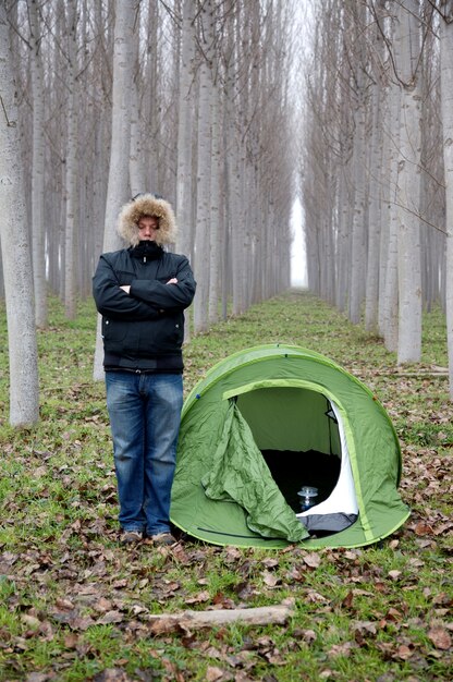 Homem sozinho na floresta com tenda de abrigo