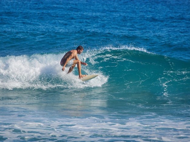 Homem surfando no Oceano Atlântico.