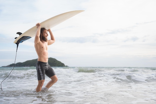 Homem surfista com sua prancha de surf na praia