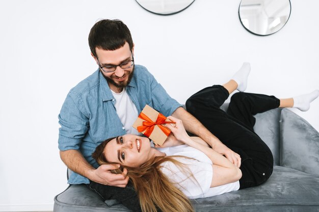 Homem surpreendeu a namorada dela com um presente, um casal feliz comemorando o dia dos namorados ou aniversário