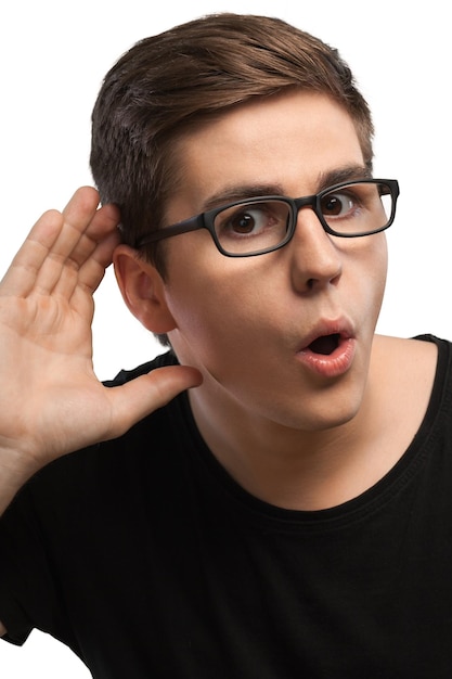 Homem surpreso com óculos ouvindo com mão na orelha, isolado