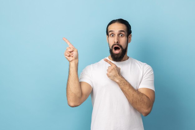 Homem surpreso mostrando espaço de cópia para parede em branco de texto comercial com apresentação de ideia