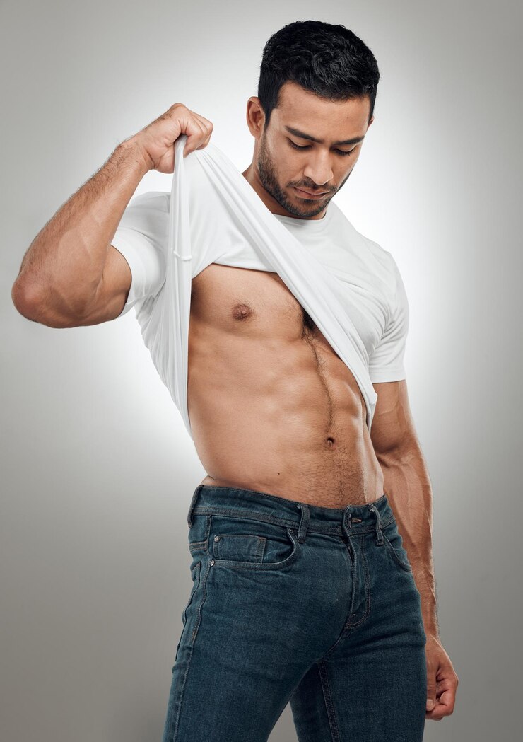 Foto homem t-shirt e tirar no estúdio para fitness bem-estar e forte músculo abdominal em fundo cinza roupa de pessoa masculina e tirar para a saúde fisiculturista e orgulhoso do corpo ou resultados de treino