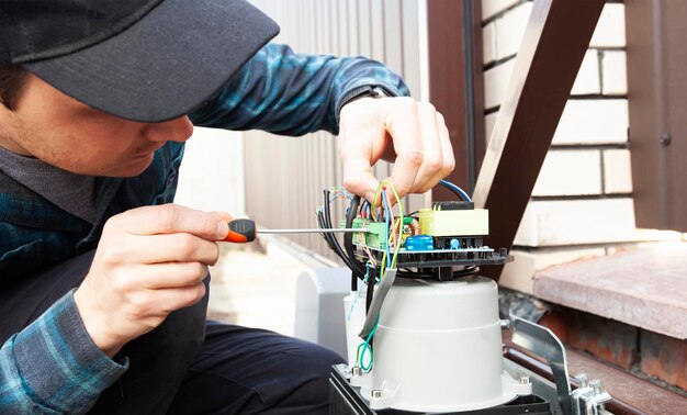 Homem técnico instalando e verificando o funcionamento do portão automático