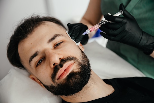 Homem tendo injeção de beleza no salão de spa masculino Tratamento antienvelhecimento para conceito de homens