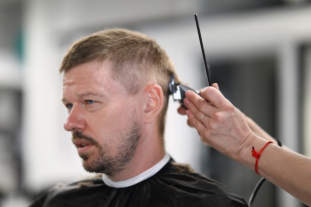 Homem tendo o cabelo cortado em retrato de barbearia