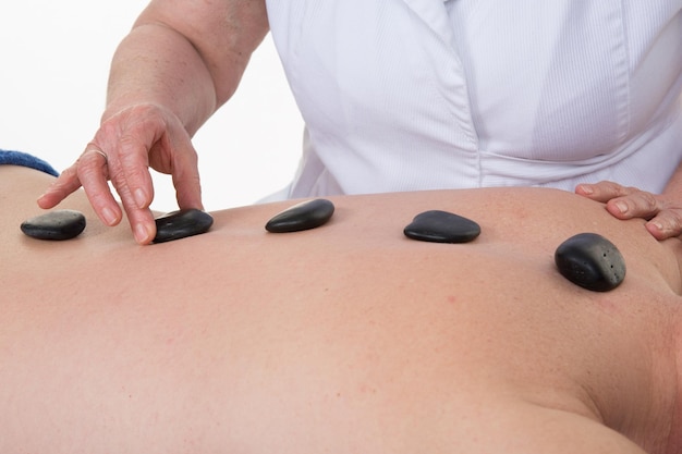 Homem tendo uma massagem com pedras quentes no centro de spa