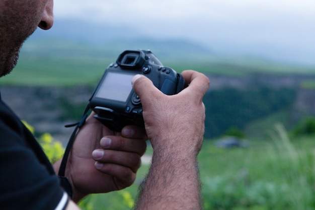 Homem tira fotos com uma câmera na natureza