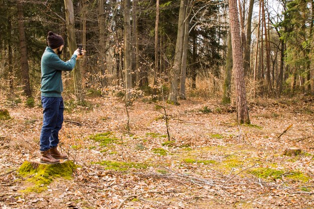 Homem tirando foto com smartphone na floresta