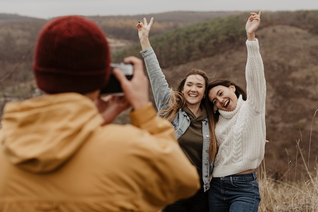 Homem tirando fotos de mulheres na natureza