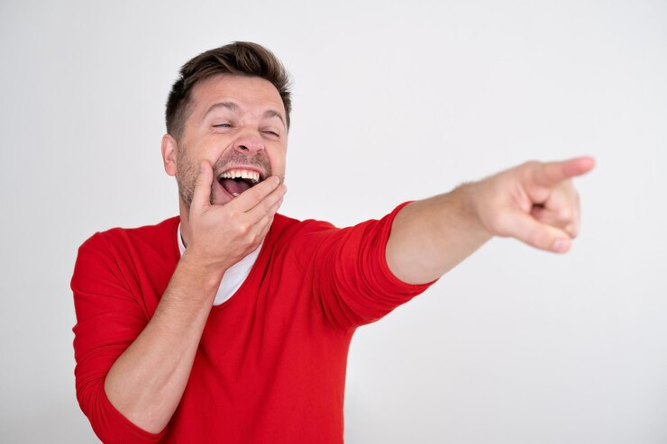 Foto homem tirando sarro de algo rindo e apontando