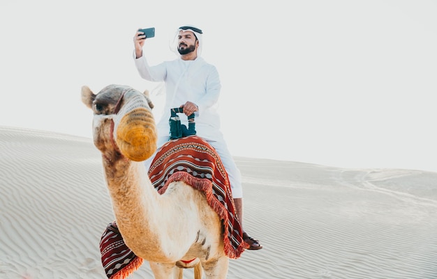 Foto homem tirando selfie enquanto anda a cavalo na sobremesa