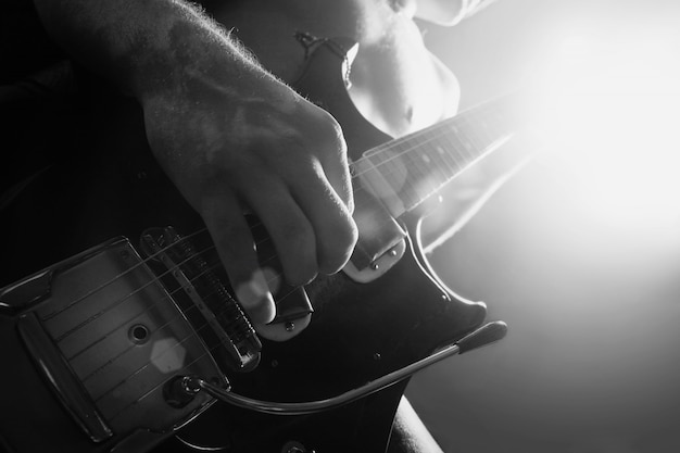 Foto homem tocando guitarra elétrica em preto e branco