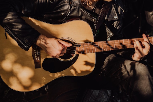 Homem tocando guitarra na natureza em um dia ensolarado