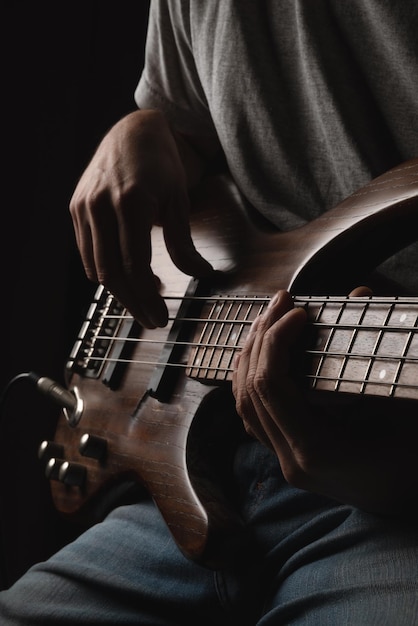 Homem tocando solo de instrumento de baixo elétrico de quatro cordas