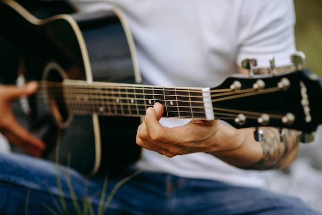 homem tocando violão de perto