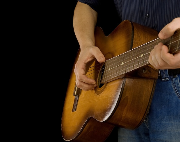 Homem tocando violão isolado no preto