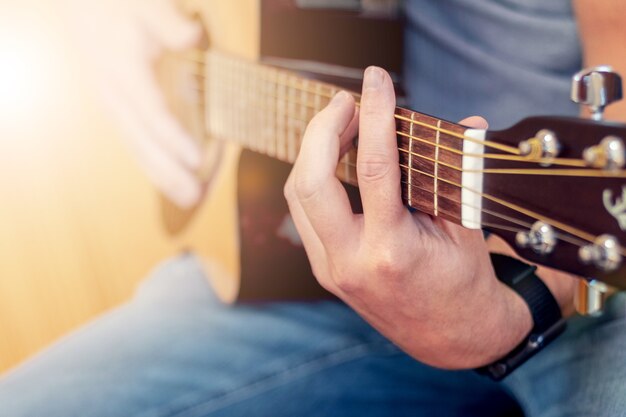 Homem tocando violão, violão perto da profundidade de campo