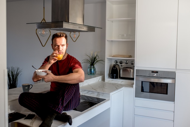 Homem tomando café da manhã pelas janelas