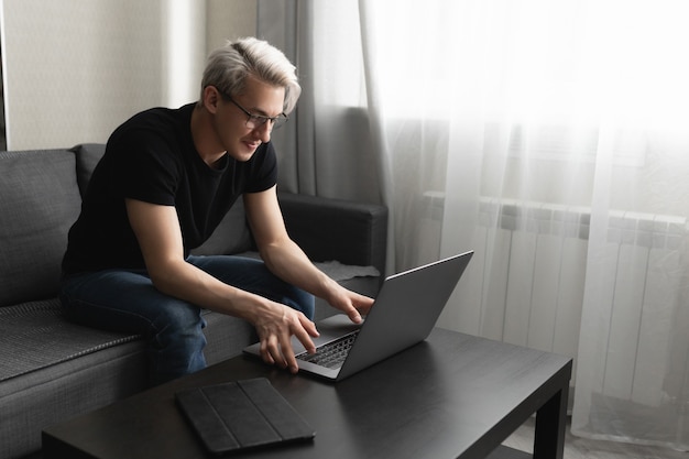 Homem trabalha em casa usando um laptop para o conceito de trabalho remoto durante uma pandemia