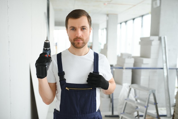 Homem trabalhador de drywall instalando placa de gesso cartonado na parede