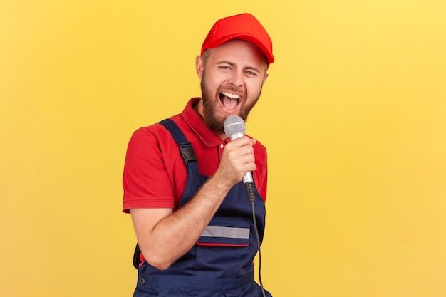 Homem trabalhador de pé com microfone nas mãos e cantando na festa corporativa se divertindo no trabalho