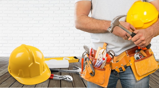 Homem trabalhador de uniforme com capacete no fundo