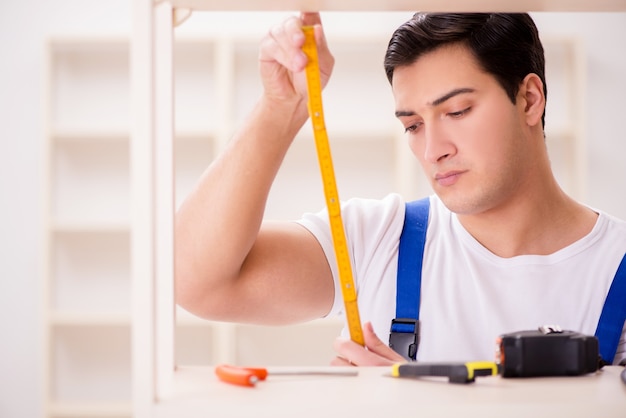 Homem trabalhador reparando montagem estante