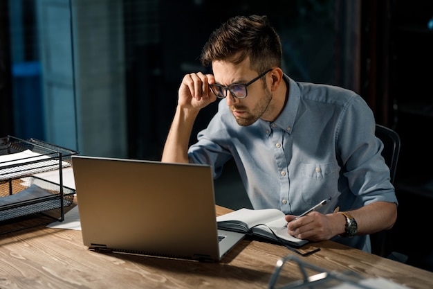 Homem trabalhando assistindo laptop com confusão