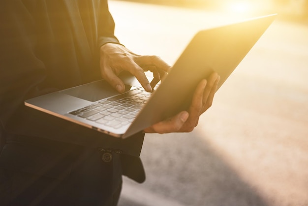 Foto homem trabalhando com laptop no fundo da manhã ao ar livre