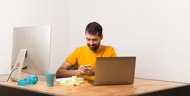 Homem, trabalhando, com, laptot, em, um, escritório, conversa móvel