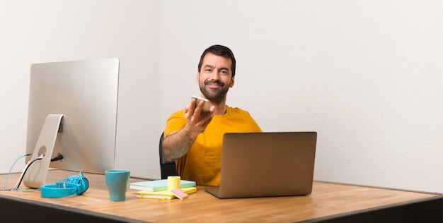 Homem, trabalhando, com, laptot, em, um, escritório, conversa móvel