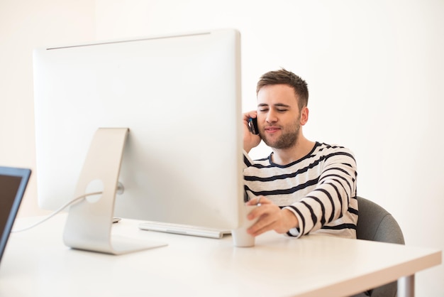 Homem trabalhando e usando telefone celular no escritório