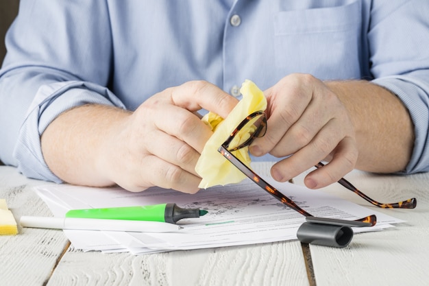 Homem trabalhando em casa, com documentos e caneta marca-texto