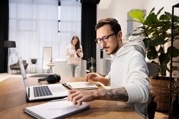 Foto homem trabalhando em casa em uma mesa com um laptop