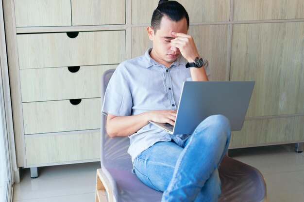 Homem trabalhando em casa. Homem estressado enquanto trabalhava em um laptop em sua sala de estar.