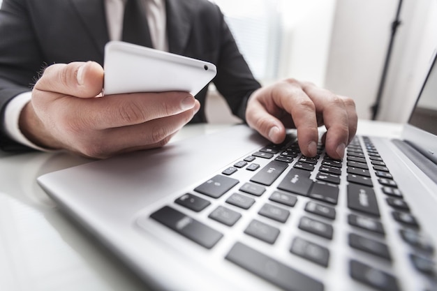 Homem trabalhando em casa usando telefone inteligente