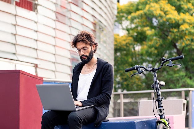 Homem trabalhando em seu laptop ao ar livre na cidade