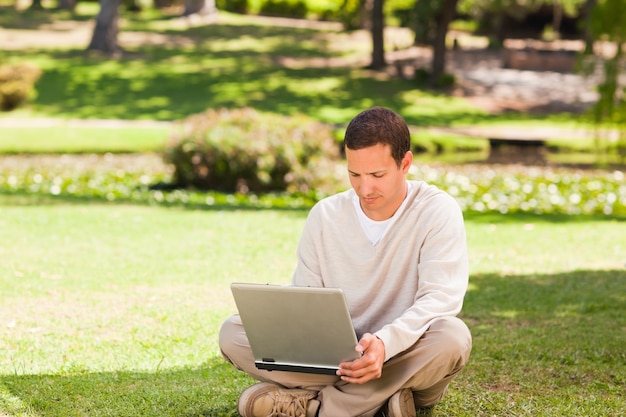 Homem trabalhando em seu laptop no parque