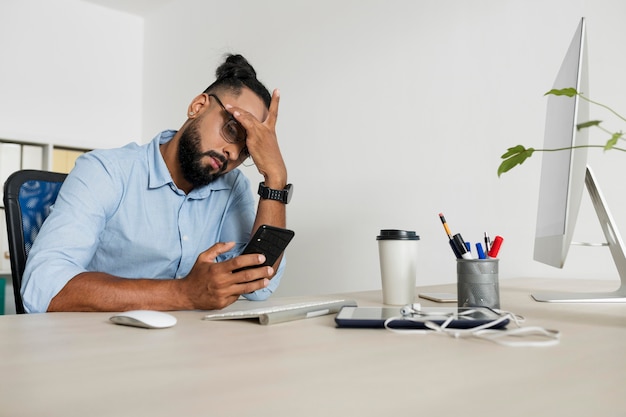 Foto homem trabalhando enquanto verifica o telefone