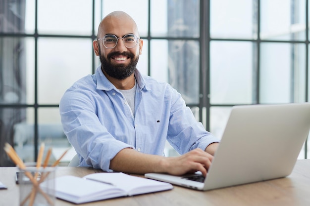 homem trabalhando na mesa com laptop em um novo escritório