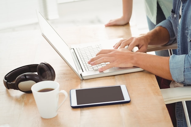 Homem trabalhando no laptop com uma mulher