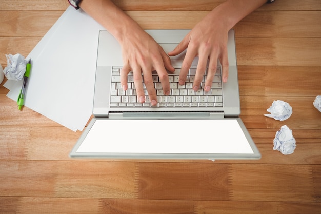 Homem trabalhando no laptop na mesa no escritório